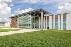 Exterior view of the new Louisiana Correctional Institute for Women featuring a modern glass entrance, wood-accented facade, and contemporary institutional design.